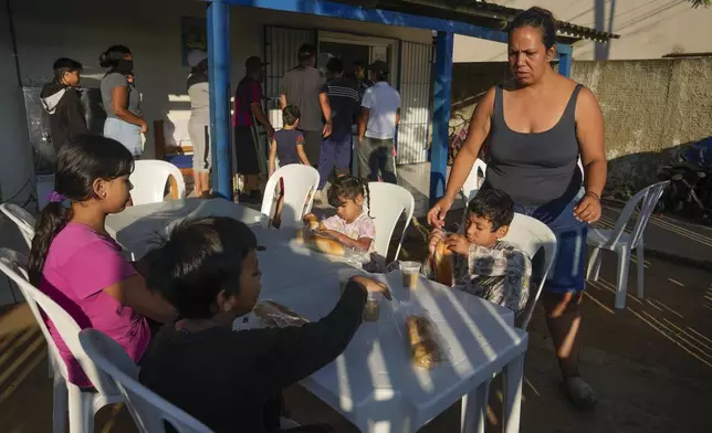 Venezuelan migrant Natalia Contreras tends to her children as they settle in to have breakfast at a shelter in Rio Branco, Brazil, Saturday, June 22, 2024. Migrants, police, officials and analysts say President Joe Biden’s halt on asylum have caused a wait-and-see attitude among migrants staying in Brazil, placing their plans of reaching the U.S. on hold. (AP Photo/Martin Mejia)