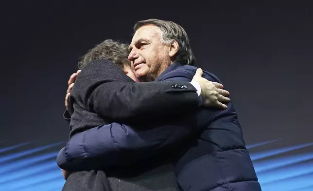 Brazil's former President Jair Bolsonaro, right, hugs Argentina's President Javier Milei at CPAC Brasil 2024, a conservative event, in Balneario Camboriu, Santa Catarina state, Brazil, Sunday, July 7, 2024. (AP Photo/Heuler Andrey)