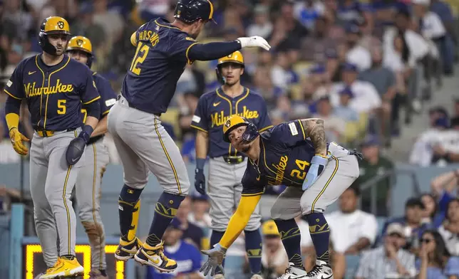 Milwaukee Brewers' Rhys Hoskins, center, is congratulated by William Contreras, right, Garrett Mitchell, left, Willy Adames, second from left, and Sal Frelick after hitting a grand slam during the fourth inning of a baseball game against the Los Angeles Dodgers Friday, July 5, 2024, in Los Angeles. (AP Photo/Mark J. Terrill)