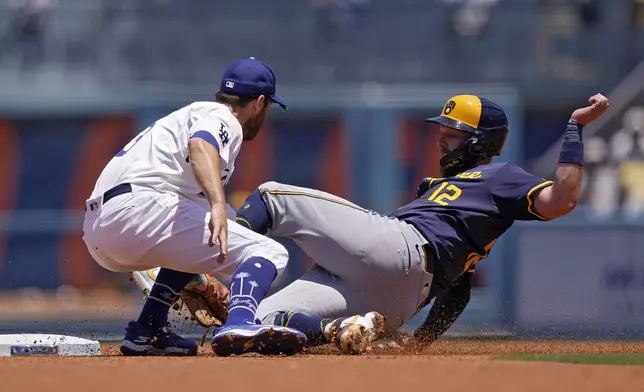 Milwaukee Brewers' Rhys Hoskins, right, is tagged out by Los Angeles Dodgers second baseman Chris Taylor as he tries to take second on a runner's fielder's choice during the first inning of a baseball game Sunday, July 7, 2024, in Los Angeles. (AP Photo/Mark J. Terrill)