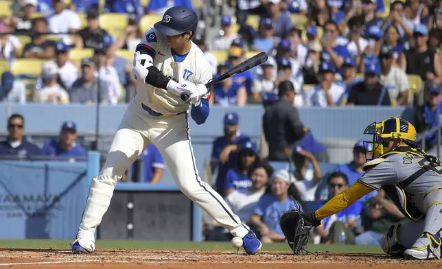 Los Angeles Dodgers' Shohei Ohtani, left, his hit by a pitch as Milwaukee Brewers catcher William Contreras catches during the second inning of a baseball game Saturday, July 6, 2024, in Los Angeles. (AP Photo/Mark J. Terrill)