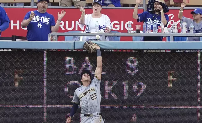 Milwaukee Brewers left fielder Christian Yelich can't get to a ball hit by Los Angeles Dodgers' Miguel Vargas for a solo home run during the eighth inning of a baseball game Saturday, July 6, 2024, in Los Angeles. (AP Photo/Mark J. Terrill)