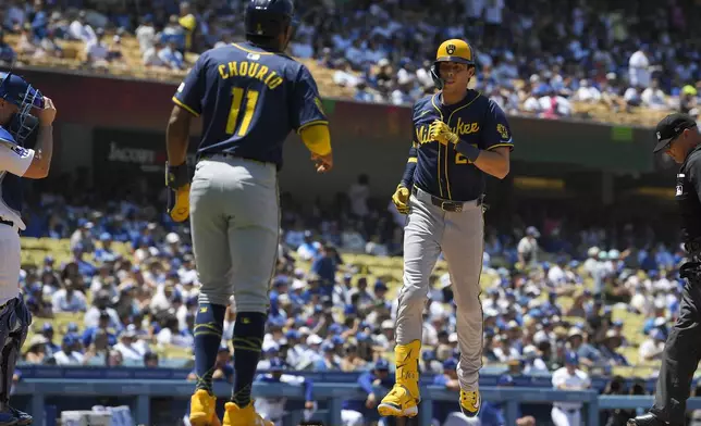 Milwaukee Brewers' Jackson Chourio, left, waits to congratulate Christian Yelich after Yelich hit a two-run home run during the fourth inning of a baseball game against the Los Angeles Dodgers Sunday, July 7, 2024, in Los Angeles. (AP Photo/Mark J. Terrill)