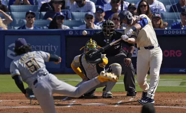 Los Angeles Dodgers' Will Smith, right, hits a two-run home run as Milwaukee Brewers starting pitcher Freddy Peralta, left, and catcher William Contreras, second from left, watch along with home plate umpire Edwin Moscoso during the first inning of a baseball game Saturday, July 6, 2024, in Los Angeles. (AP Photo/Mark J. Terrill)