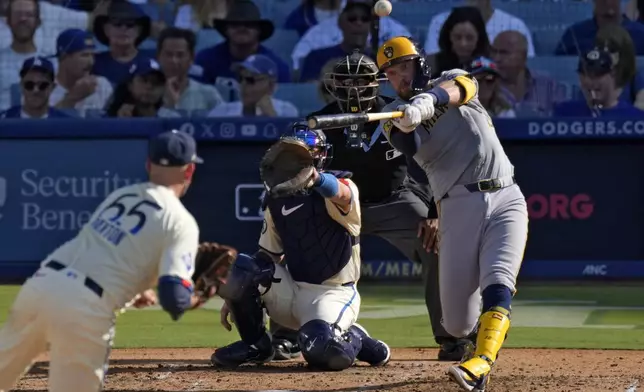 Milwaukee Brewers' Rhys Hoskins, right, hits a solo home run as Los Angeles Dodgers starting pitcher James Paxton, left, and catcher Will Smith, second from left, watch along with home plate umpire Edwin Moscoso during the fourth inning of a baseball game Saturday, July 6, 2024, in Los Angeles. (AP Photo/Mark J. Terrill)