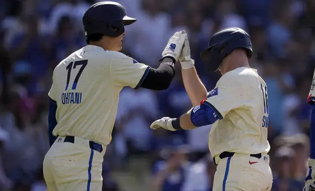 Los Angeles Dodgers' Will Smith, right, is congratulated by Shohei Ohtani after hitting a two-run home run during the first inning of a baseball game against the Milwaukee Brewers Saturday, July 6, 2024, in Los Angeles. (AP Photo/Mark J. Terrill)