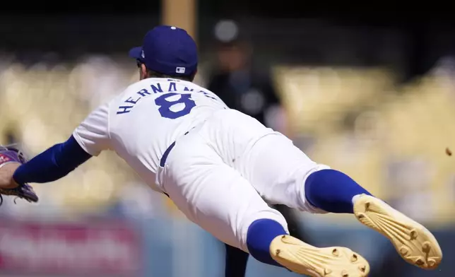 Los Angeles Dodgers third baseman Kiké Hernández dives for a ball hit for an RBI single by Milwaukee Brewers' Blake Perkins during the eighth inning of a baseball game Sunday, July 7, 2024, in Los Angeles. (AP Photo/Mark J. Terrill)