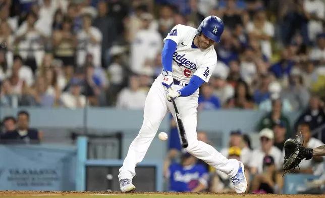 Los Angeles Dodgers' Freddie Freeman hits a two RBI single during the eighth inning of a baseball game against the Milwaukee Brewers Friday, July 5, 2024, in Los Angeles. (AP Photo/Mark J. Terrill)