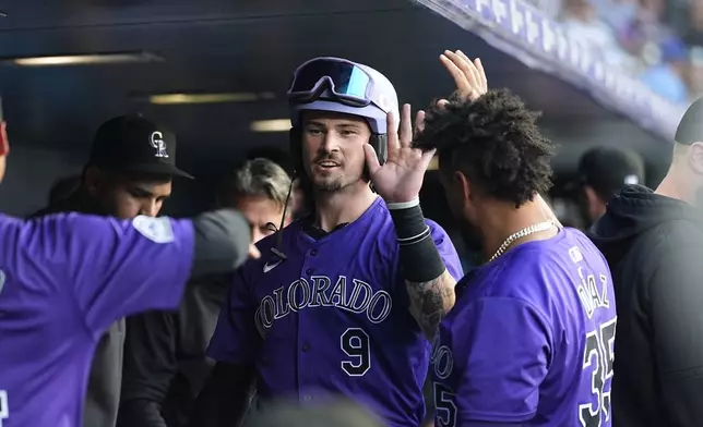 Colorado Rockies' Brenton Doyle, center, is congratulated as he returns to the dugout after hitting a solo home run agianst the Milwaukee Brewers in the second inning of a baseball game Tuesday, July 2, 2024, in Denver. (AP Photo/David Zalubowski)
