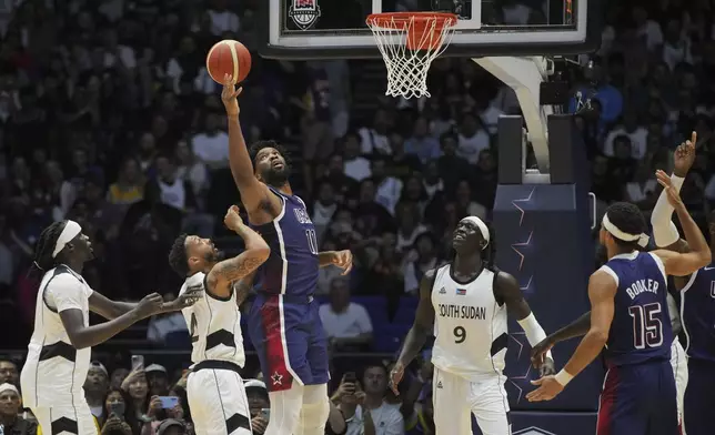 United States' center Joel Embiid, (11), attempts to score under pressure from South Sudan's guard Carlik Jones, (4), during an exhibition basketball game between the United States and South Sudan, at the o2 Arena in London, Saturday, July 20, 2024. (AP Photo/Kin Cheung)