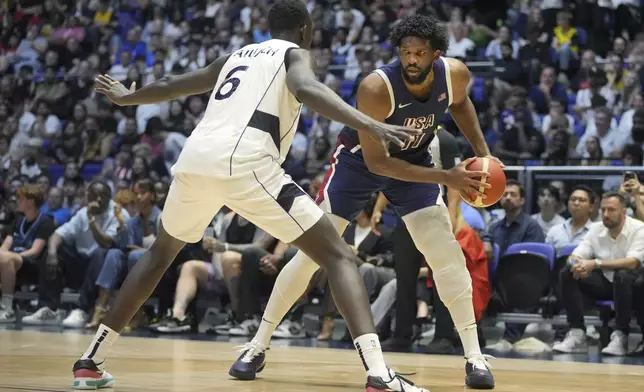 United States' center Joel Embiid, right, looks to pass as South Sudan's center Khaman Maluach defends during an exhibition basketball game between the United States and South Sudan, at the o2 Arena in London, Saturday, July 20, 2024. (AP Photo/Kin Cheung)