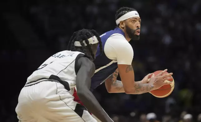 United States' forward Anthony Davis, right, looks to pass the ball as South Sudan's forward Wenyen Gabriel defends during an exhibition basketball game between the United States and South Sudan, at the o2 Arena in London, Saturday, July 20, 2024. (AP Photo/Kin Cheung)