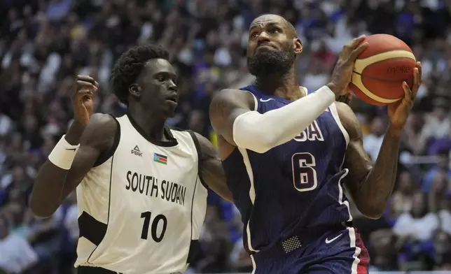 United States' forward LeBron James, right, goes for the basket as South Sudan's forward JT Thor defends during an exhibition basketball game between the United States and South Sudan, at the o2 Arena in London, Saturday, July 20, 2024. (AP Photo/Kin Cheung)