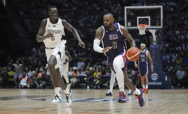 United States' forward LeBron James runs as he advances to score as South Sudan's center Khaman Maluach attempts to defend during an exhibition basketball game between the United States and South Sudan, at the o2 Arena in London, Saturday, July 20, 2024. (AP Photo/Kin Cheung)