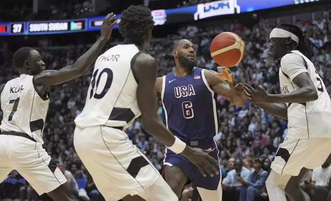 United States' forward LeBron James, (6), reaches for the ball under pressure from South Sudan's forward Nuni Omot, right, South Sudan's forward JT Thor, (10), and South Sudan's guard Bul Kuol, left, during an exhibition basketball game between the United States and South Sudan, at the o2 Arena in London, Saturday, July 20, 2024. (AP Photo/Kin Cheung)