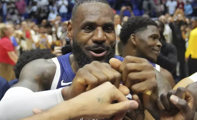 United States' forward LeBron James bumps fists with teammates after the end of an exhibition basketball game between the United States and South Sudan, at the o2 Arena in London, Saturday, July 20, 2024. (AP Photo/Kin Cheung)