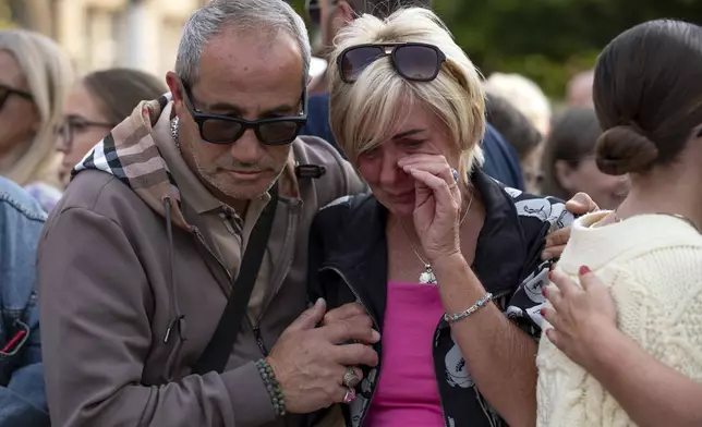 Members of the public take part in a vigil near the scene in Hart Street, in Southport, England, Tuesday, July 30, 2024, where three children died and eight were injured in a knife attack during a Taylor Swift event at a dance school on Monday. (James Speakman/PA via AP)