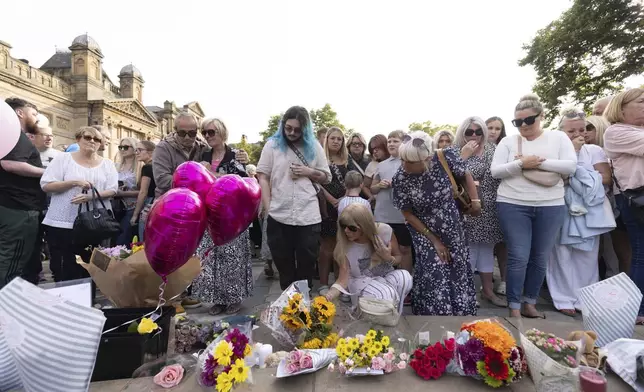 Members of the public take part in a vigil near the scene in Hart Street, in Southport, England, Tuesday, July 30, 2024, where three children died and eight were injured in a knife attack during a Taylor Swift event at a dance school on Monday. (James Speakman/PA via AP)