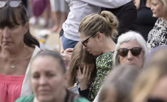 Members of the public take part in a vigil near the scene in Hart Street, in Southport, England, Tuesday, July 30, 2024, where three children died and eight were injured in a knife attack during a Taylor Swift event at a dance school on Monday. (James Speakman/PA via AP)