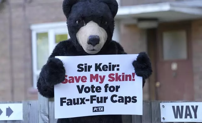 A PETA activist , People for the Ethical Treatment of Animals, dressed as a bear holds a poster in front of a polling station in London, Thursday, July 4, 2024. Voters in the U.K. are casting their ballots in a national election to choose the 650 lawmakers who will sit in Parliament for the next five years. Outgoing Prime Minister Rishi Sunak surprised his own party on May 22 when he called the election, which could have taken place as late as January 2025. Polls opened at 7 a.m. and will close at 10 p.m. on Thursday night. (AP Photo/Vadim Ghirda)
