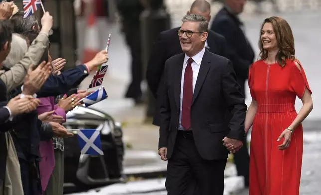 Britain's Labour Party Prime Minister Keir Starmer and his wife Victoria arrive in Downing Street and greet supporters in London, Friday, July 5, 2024. Labour leader Stammer won the general election on July 4, and was appointed Prime Minster by King Charles III at Buckingham Palace, after the party won a landslide victory. (AP Photo/Vadim Ghirda)