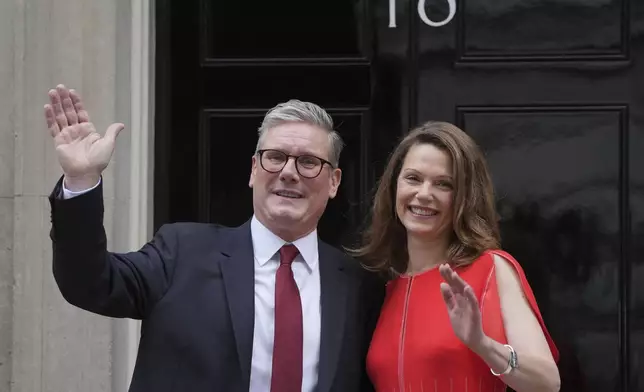 Britain's Labour Party Prime Minister Keir Starmer and his wife Victoria wave to the crowds of supporters and media from the doorstep of 10 Downing Street in London, Friday, July 5, 2024. Labour leader Starmer won the general election on July 4, and was appointed Prime Minster by King Charles III at Buckingham Palace, after the party won a landslide victory. (AP Photo/Kin Cheung)