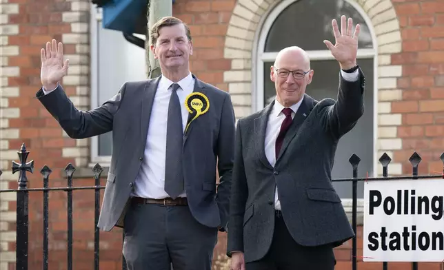 Scottish First Minister and SNP leader John Swinney, right, stands with local parliamentary candidate for Angus and Perthshire Glens, Dave Doogan, after casting his vote outside the 2024 General Election polling station at Burreltown Village Hall in Blairgowrie, Scotland, Thursday July 4, 2024. (Jane Barlow/PA via AP)