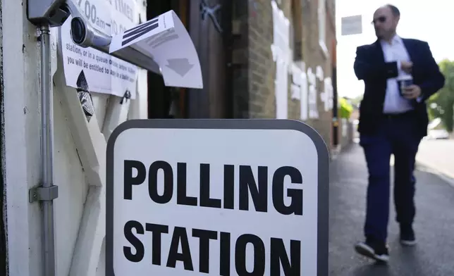 A man walks into a temporary polling station at Wimbledon Village, London, Thursday, July 4, 2024. Voters in the U.K. are casting their ballots in a national election to choose the 650 lawmakers who will sit in Parliament for the next five years.(AP Photo/Mark Baker)