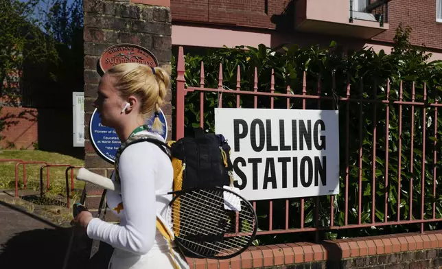 A woman walks past a temporary polling station near Wimbledon, London, Thursday, July 4, 2024. Voters in the U.K. are casting their ballots in a national election to choose the 650 lawmakers who will sit in Parliament for the next five years.(AP Photo/Alberto Pezzali)