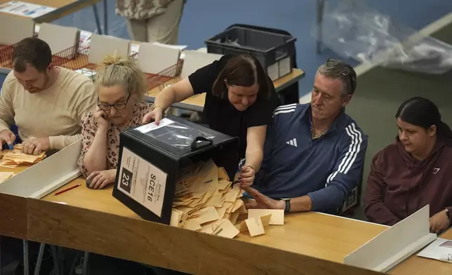 Ballot boxes are emptied at Silkworth Community Pool Tennis &amp; Wellness Centre in Sunderland, England, during the count for the 2024 General Election, Thursday, July 4, 2024. Britain’s Labour Party was headed for a huge majority in Britain’s election on Thursday, an exit poll suggested. (Owen Humphreys/PA via AP)