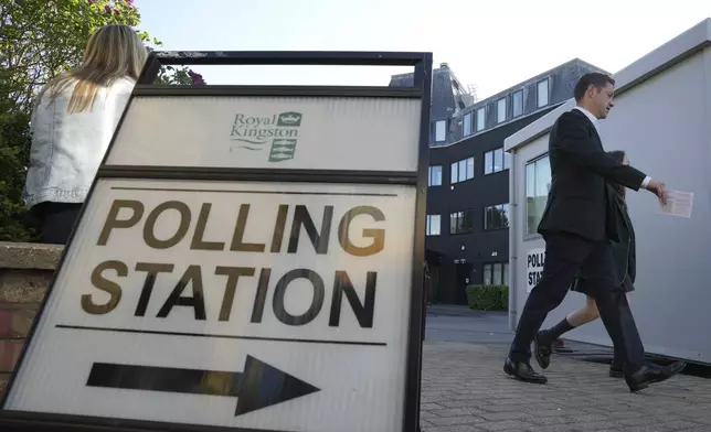People go to cast their vote in a temporary polling station next to Norbiton railway station London Thursday, July 4, 2024. Britain goes to the polls Thursday after Prime Minister Rishi Sunak called a general election. (AP Photo/Kin Cheung)