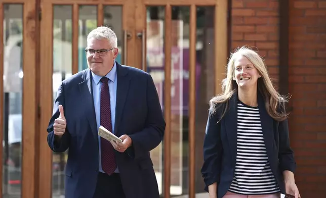 DUP leader Gavin Robinson, left, gives the thumbs up after after casting his vote with his wife Lindsay in the 2024 General Election at Dundonald Elim Church in Belfast, Northern Ireland, Thursday July 4, 2024. (Liam McBurneyPA via AP)