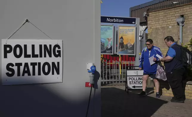 People go to vote in a temporary polling station next to Norbiton railway station London Thursday, July 4, 2024. Britain goes to the polls Thursday after Prime Minister Rishi Sunak called a general election. (AP Photo/Kin Cheung)