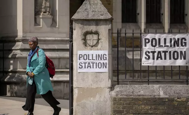 A woman exits a polling station set up at St George's Cathedral in London, Thursday, July 4, 2024. Voters in the U.K. are casting their ballots in a national election to choose the 650 lawmakers who will sit in Parliament for the next five years. (AP Photo/Vadim Ghirda)