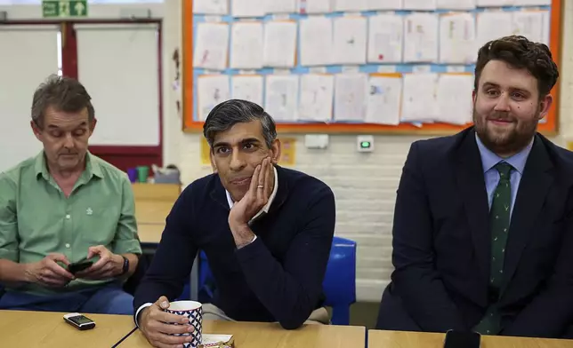 Britain's Prime Minister Rishi Sunak looks on as journalists ask him questions, during a visit to Braishfield primary school as part of a Conservative general election campaign event in Hampshire, England, Wednesday July 3, 2024. (Claudia Greco/Pool Photo via AP)