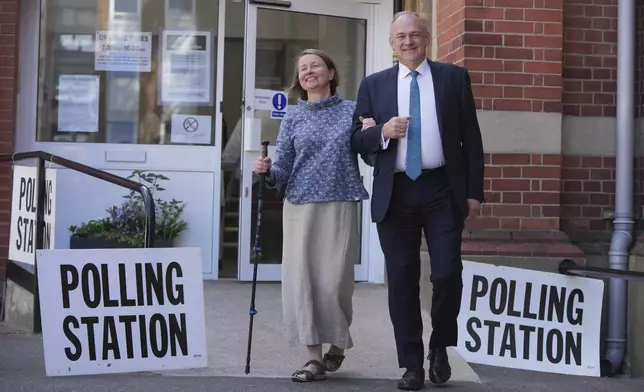 Britain's LibDem party leader Ed Davey and his wife Emily Daveypose for the media after they cast their vote at polling station in Kingston, London, Thursday, July 4, 2024. Britain goes to the polls Thursday after Prime Minister Rishi Sunak called a general election.(AP Photo/Kin Cheung)