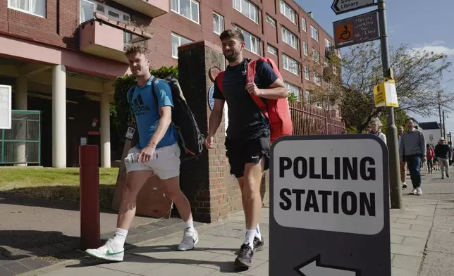 People walk past a temporary polling station near Wimbledon, London, Thursday, July 4, 2024. Voters in the U.K. are casting their ballots in a national election to choose the 650 lawmakers who will sit in Parliament for the next five years. (AP Photo/Alberto Pezzali)