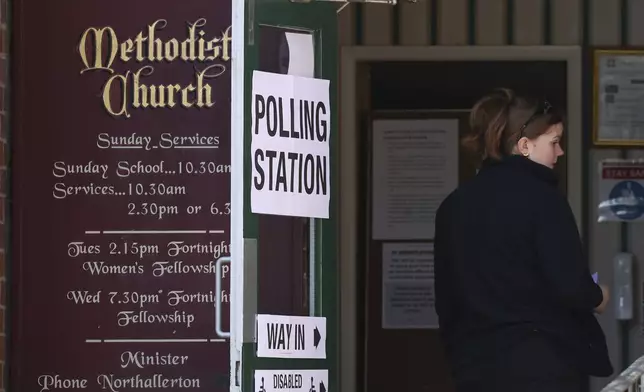 A woman goes to cast her vote in a polling station at Brompton Methodist church in Northallerton, North Yorkshire, England, Thursday, July 4, 2024. Britain goes to the polls Thursday after Prime Minister Rishi Sunak called a general election.(AP Photo/)
