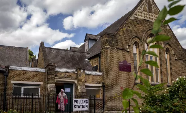 A woman exits a polling station set up at St. Anne's Church, Bermondsey, in London, Thursday, July 4, 2024. Voters in the U.K. are casting their ballots in a national election to choose the 650 lawmakers who will sit in Parliament for the next five years. Outgoing Prime Minister Rishi Sunak surprised his own party on May 22 when he called the election. (AP Photo/Vadim Ghirda)