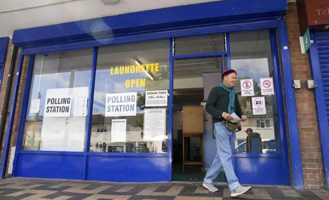 A man leaves after casting his ballot at a polling station installed inside a launderette for the 2024 General Election, in Oxford, England, Thursday July 4, 2024. (Jacob King/PA via AP)