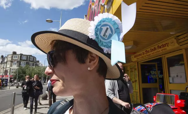 A woman displays a Reform UK Party badge on her hat in Clacton On Sea, England, Thursday, July 4, 2024. Voters in the U.K. are casting their ballots in a national election to choose the 650 lawmakers who will sit in Parliament for the next five years. Outgoing Prime Minister Rishi Sunak surprised his own party on May 22 when he called the election. (AP Photo/Thomas Krych)