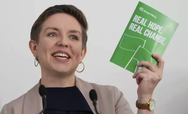 FILE - Green Party co-leader Carla Denyer holds up a manifesto as she speaks at their General Election Manifesto launch in Hove, East Sussex, England, on June 12, 2024. (AP Photo/Kirsty Wigglesworth, File)