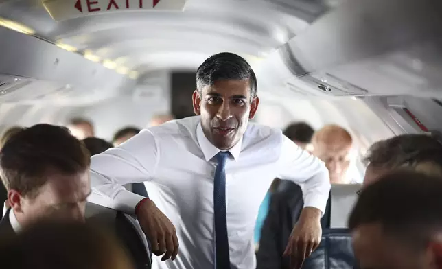 FILE - British Prime Minister Rishi Sunak talks to journalists on his plane as he travels from Northern Ireland to Birmingham during a day of campaigning for this year's General Election due to be held on July 4, on Friday May 24, 2024. The United Kingdom will hold its first national election in almost five years on Thursday, with opinion polls suggesting that Prime Minister Rishi Sunak’s Conservative Party will be punished for failing to deliver on promises made during 14 years in power. (Henry Nicholls/Pool photo via AP, File)
