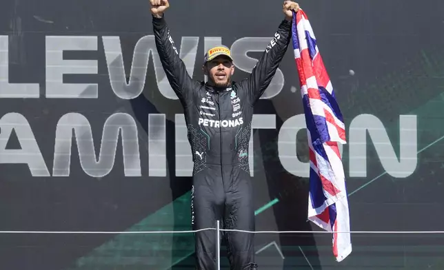 Mercedes driver Lewis Hamilton of Britain celebrates on the podium after winning the British Formula One Grand Prix race at the Silverstone racetrack, Silverstone, England, Sunday, July 7, 2024. (AP Photo/Luca Bruno)