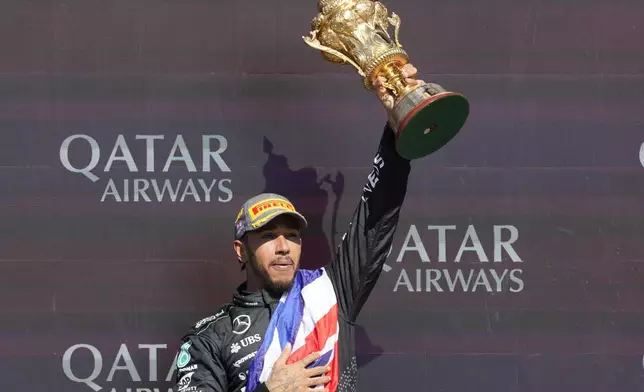 Mercedes driver Lewis Hamilton of Britain celebrates on the podium after winning the British Formula One Grand Prix race at the Silverstone racetrack, Silverstone, England, Sunday, July 7, 2024. (AP Photo/Luca Bruno)