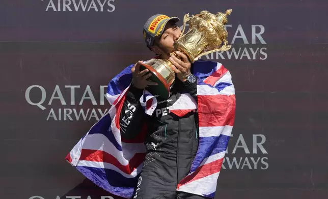 Mercedes driver Lewis Hamilton of Britain celebrates on the podium after winning the British Formula One Grand Prix race at the Silverstone racetrack, Silverstone, England, Sunday, July 7, 2024. (AP Photo/Luca Bruno)