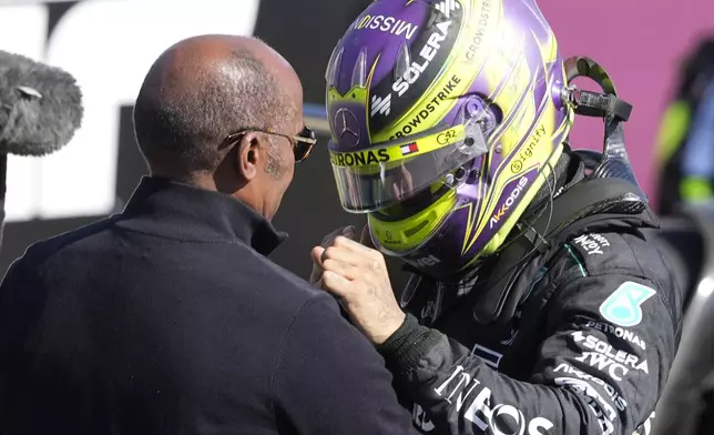 Mercedes driver Lewis Hamilton of Britain celebrates with his father after winning the British Formula One Grand Prix race at the Silverstone racetrack, Silverstone, England, Sunday, July 7, 2024. (AP Photo/Luca Bruno)