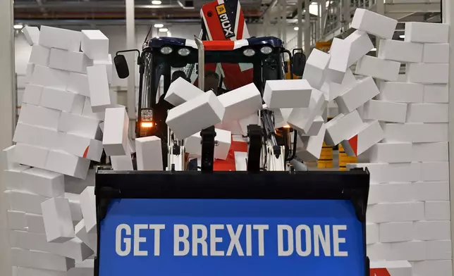 FILE - Britain's Prime Minister Boris Johnson drives a JCB through a symbolic wall with the Conservative Party slogan 'Get Brexit Done' in the digger bucket, during an election campaign event at the JCB manufacturing facility in Uttoxeter, England, Dec. 10, 2019. The U.K. election in December 2019 was basically about one issue: Brexit. General elections in the U.K. are typically held in the spring or early summer. But in the fall of 2019, the recently-appointed Prime Minister Boris Johnson gambled on holding one on Dec. 12, when most people just want to get ready for Christmas and would rather think of anything but politics. (Ben Stansall/Pool via AP, File)