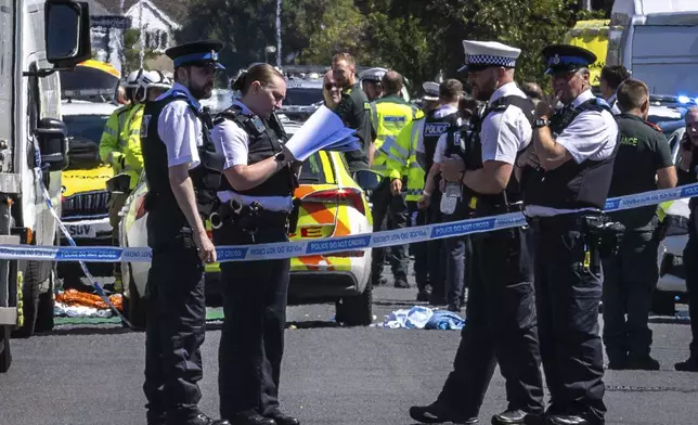 Police secure the area, where a man has been detained and a knife has been seized after a number of people were injured in a reported stabbing, in Southport, Merseyside, England, Monday July 29, 2024. (James Speakman/PA via AP)