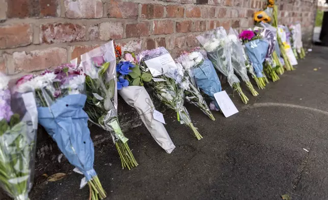 Floral tributes near the scene in Hart Street, Southport, Britain, Tuesday July 30, 2024, where two children died and nine were injured in a "ferocious" knife attack during a Taylor Swift event at a dance school on Monday. A 17-year-old male from Banks, Lancashire, has been arrested on suspicion of murder and attempted murder over the incident. (James Speakman/PA via AP)